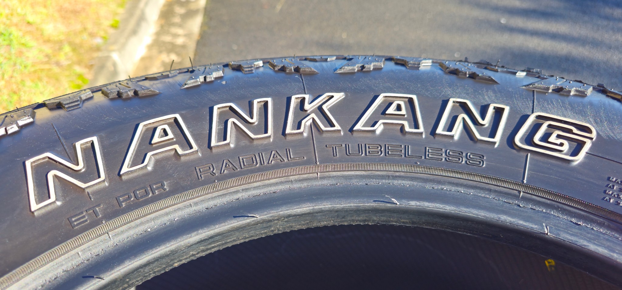 Marcas POR, RADIAL y TUBELESS en el flanco de un Nankang Conqueror R/T