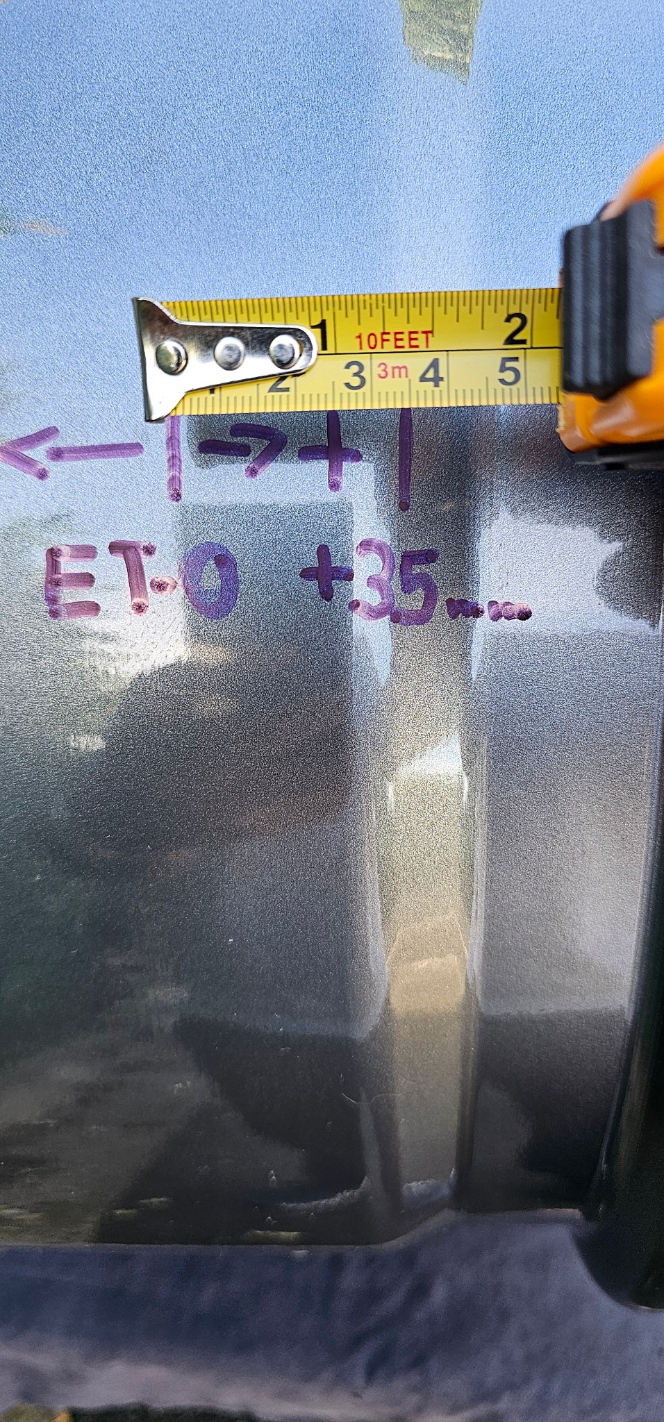 Detalle de las marcas de rotulador ET-0 y +35 sobre el barril de la llanta, con el metro al lado
